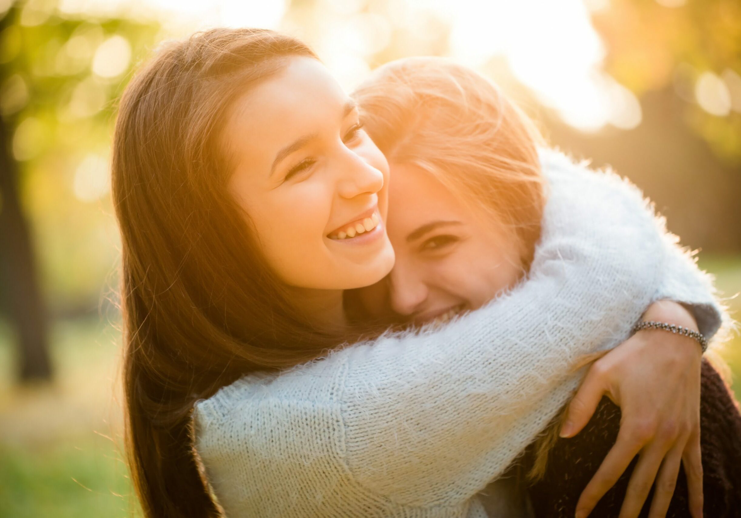 Two friends -  teenage girls hugging  outdoor in autumn at sunset